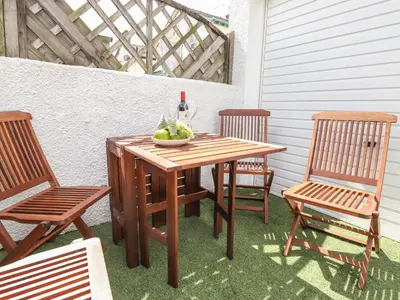 a wooden table with two chairs and a bottle of wine at Dovestones in Keswick