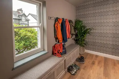 a room with a window with jackets hanging on the wall at Fellpack House in Keswick