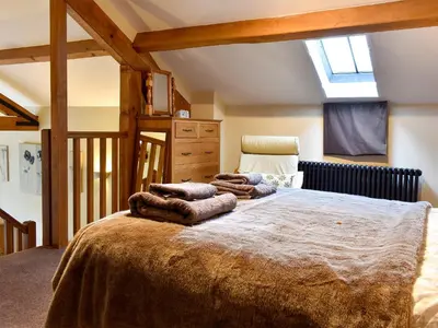 a bedroom with a large bed with towels on it at Hilltoft Barn in Dockray