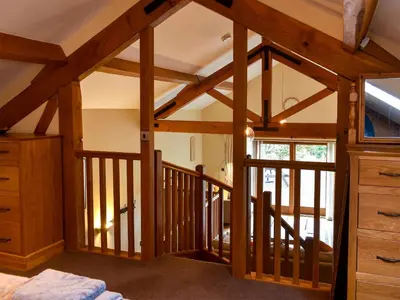 a room with a staircase with wooden beams at Hilltoft Barn in Dockray