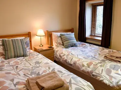 two beds sitting next to each other in a bedroom at Hilltoft Barn in Dockray