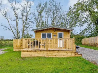 a small wooden cabin with a wooden fence at Starling Lodge - Uk31071 in Westward