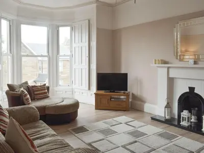 a living room with a tv and a fireplace at Charlotte Street in Ayr