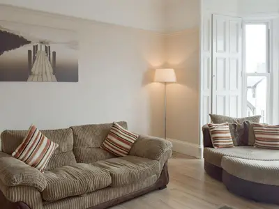 a living room with a couch and a chair at Charlotte Street in Ayr