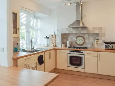 a kitchen with a stove and a clock on the wall at Southcroft Lodge in Whiting Bay