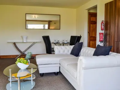 a living room with two white couches and a table at Seaviews And Hot Tub At The Fairways - Uk39821 in Portpatrick