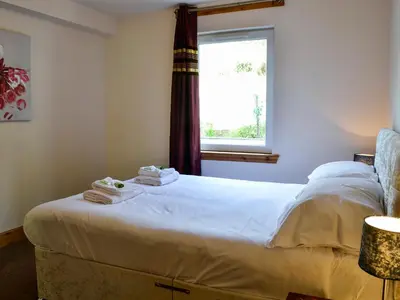 a bedroom with a large white bed with a window at Seaviews And Hot Tub At The Fairways - Uk39821 in Portpatrick