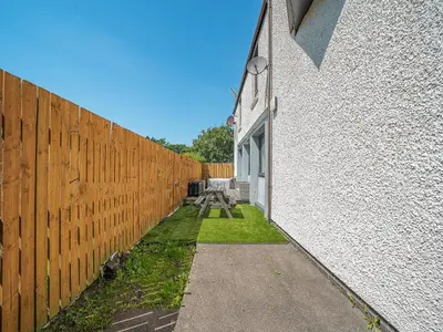 a fence with a picnic table next to a building at 1 Ladyknowe - Uk39970 in Moffat