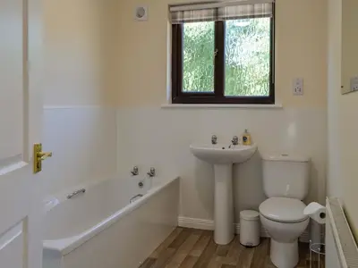 a bathroom with a sink and a toilet and a bath tub at Park Lane in Auldgirth