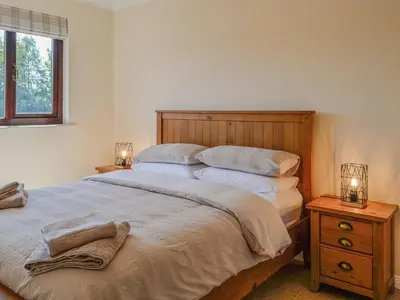 a bedroom with a large bed and two night stands at Park Lane in Auldgirth