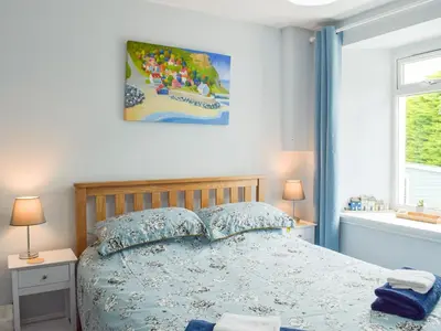 a bedroom with a bed and two lamps and a window at Seacliffe in Kildonan