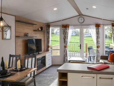 a kitchen and living room with a table and a tv at Willow - Uk36374 in Westward