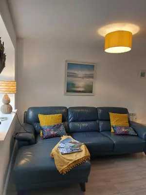 a living room with a blue couch in a room at Hill Street Cottage in Portpatrick