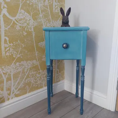 a blue end table with a rabbit sitting on top at Hill Street Cottage in Portpatrick