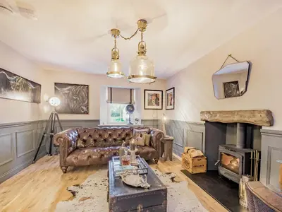 a living room with a couch and a fireplace at Keepers Cottage in Durisdeer