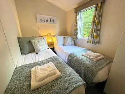 a small room with two beds and a window at Beautiful 3BR Holiday Home in Stunning Location - Pass the Keys in Moffat