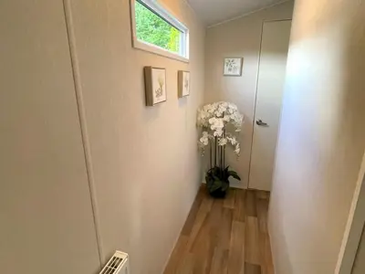 a hallway with a vase of flowers and a window at Beautiful 3BR Holiday Home in Stunning Location - Pass the Keys in Moffat