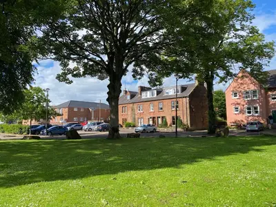 a tree in the middle of a grass field at Beautiful Apartment - Outstanding Central Location - Pass the Keys in Dumfries