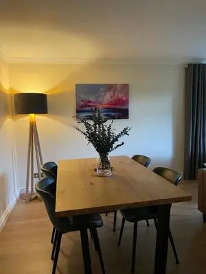 a dining room table with a vase of flowers on it at Turnberry Apartment - Ailsa Gem in Turnberry