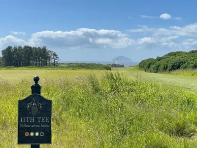 a sign in the middle of a field of grass at Turnberry Apartment - Ailsa Gem in Turnberry