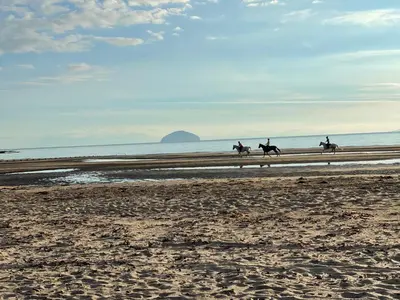 a group of people riding horses on the beach at Turnberry Apartment - Ailsa Gem in Turnberry