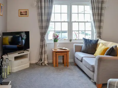 a living room with a couch and a tv at Number 7 in Gatehouse of Fleet