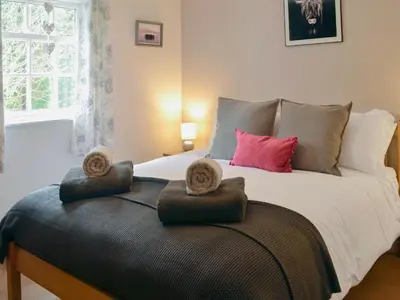 a bedroom with a large bed with towels on it at Number 7 in Gatehouse of Fleet