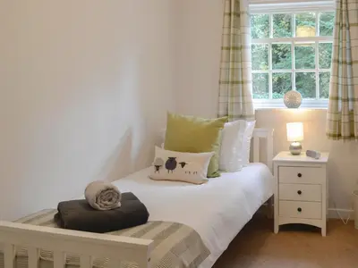 a white bed in a room with a window at Number 7 in Gatehouse of Fleet