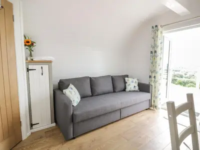 a gray couch in a living room with a window at Laird Lodge 3 in Lockerbie