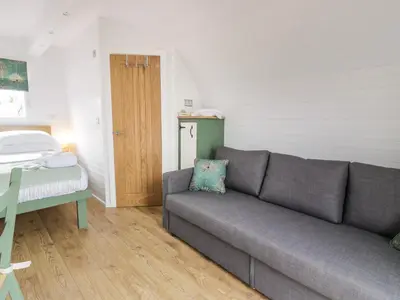 a living room with a couch and a bed at Laird Lodge 5 in Lockerbie