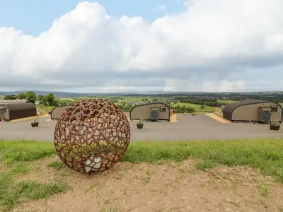 a sculpture of an egg sitting in the grass at Laird Lodge 2 in Lockerbie