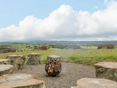 a vase sitting on top of a field with some rocks at Laird Lodge 2 in Lockerbie
