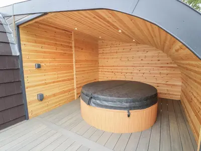 a sauna with a large wooden tub with a round stool at Laird Lodge 1 in Lockerbie