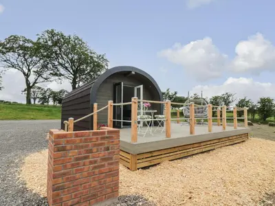 a small black dome house with a brick wall at Laird Lodge 1 in Lockerbie