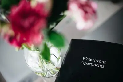 a vase filled with pink flowers next to a sign at Waterfront Apartments in Douglas