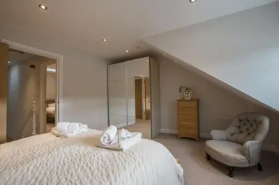 a bedroom with a bed and a chair and a mirror at Waterfront Apartments in Douglas