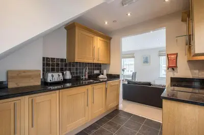 a kitchen with wooden cabinets and a counter top at Waterfront Apartments in Douglas