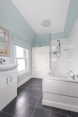 a white bathroom with a tub and a sink at The Knowe in Portpatrick