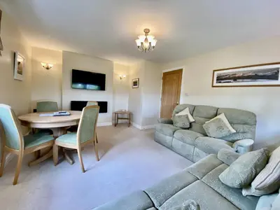 a living room with a couch and a table at 8 Howrahs Court, Keswick in Keswick