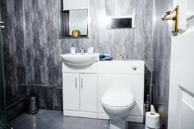 a bathroom with a white sink and a toilet at Rigside House in Douglas