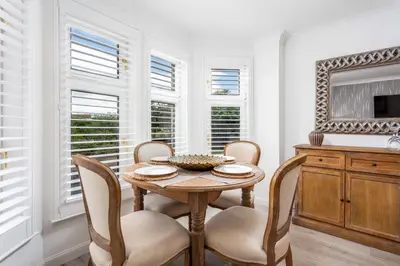 a dining room with a table and chairs and windows at 9A Millbrae - Donnini Apartments in Ayr