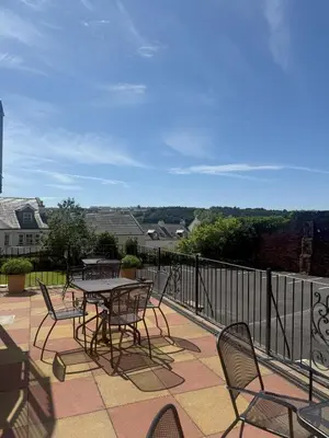 a patio with a table and chairs on a balcony at Chase Hotel in Whitehaven