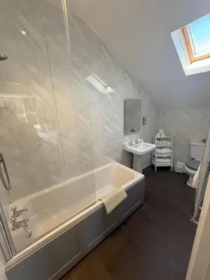 a bathroom with a bath tub and a sink at Chase Hotel in Whitehaven
