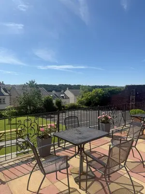 a patio with tables and chairs and a fence at Chase Hotel in Whitehaven