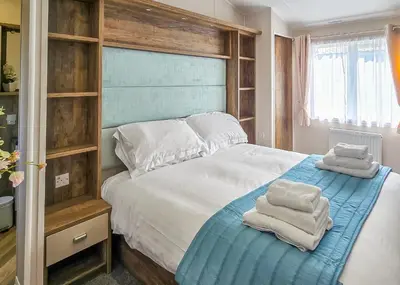 a bedroom with a bed with towels on it at Bennane Shore Holiday Park in Lendalfoot