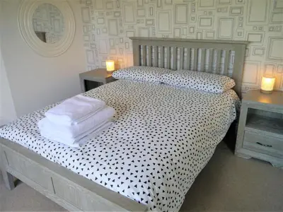 a bedroom with a bed with towels on it at Driftwood in Kippford
