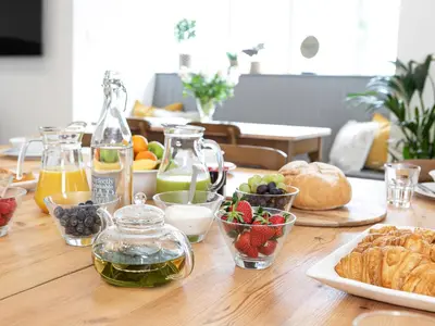 a wooden table with food and drinks and fruit on it at Thorney How in Ambleside