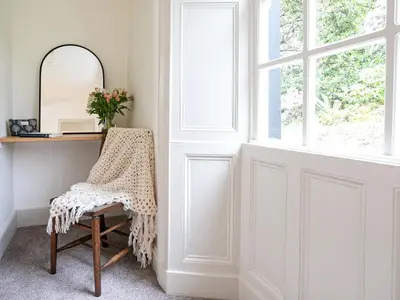 a dressing room with a mirror and a chair at Thorney How in Ambleside