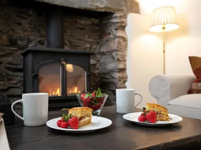 two plates of food on a table in front of a fireplace at Little How in Ambleside
