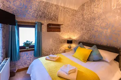 a bedroom with a bed with towels on it at Neptunes Rest Guest Hotel in Stranraer